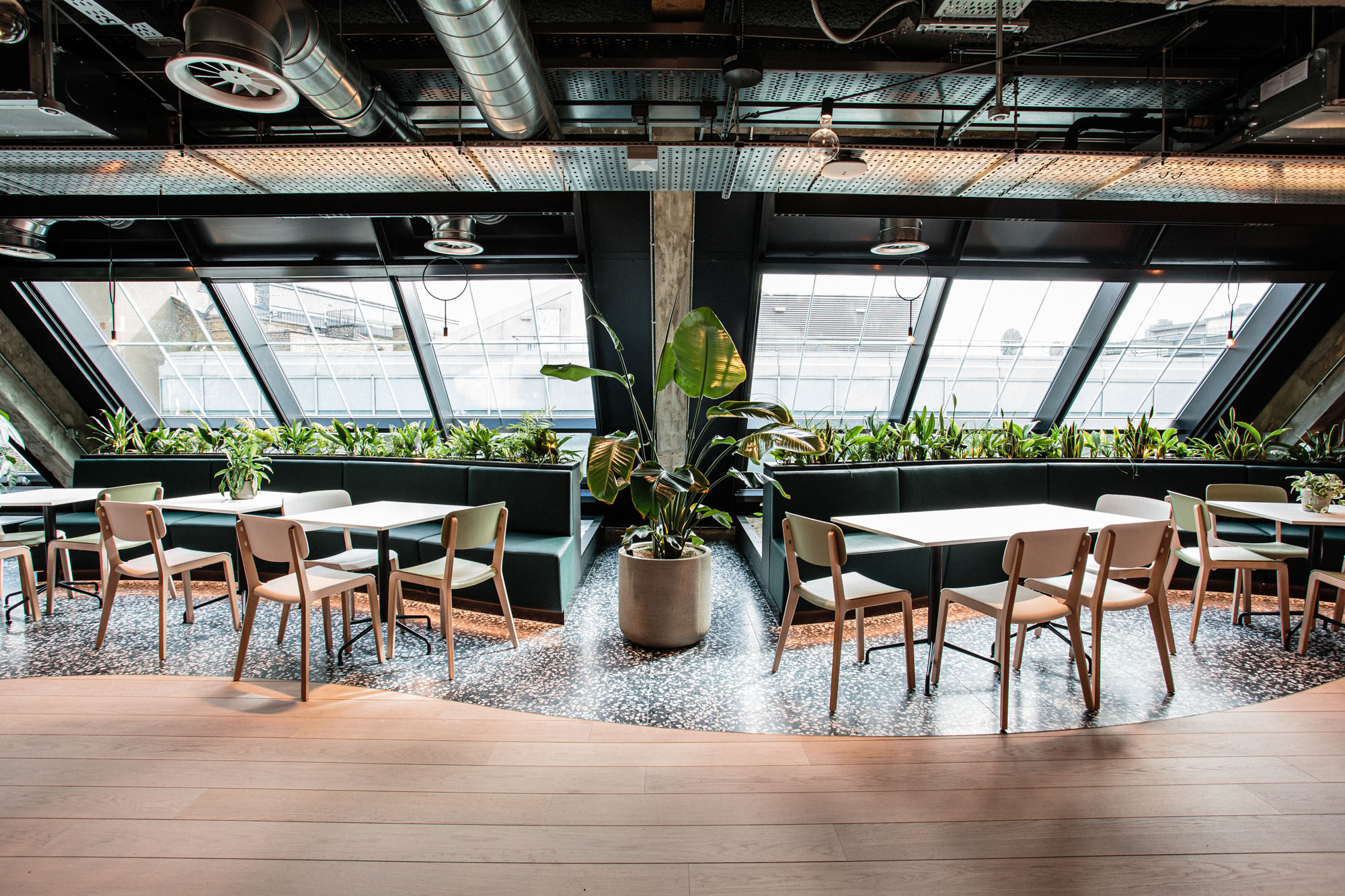 plants in bed behind tables and chairs