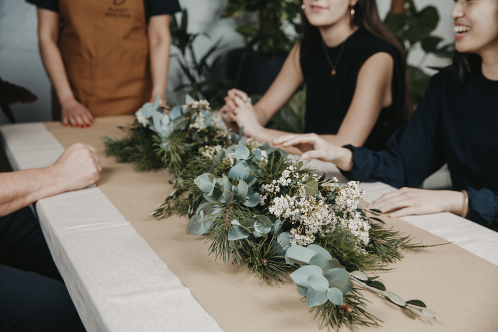 foliage garland on a table surrounded by people at a workshop