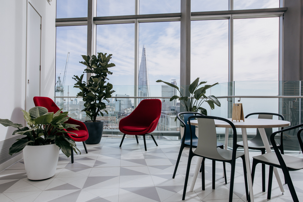 Office with large windows, seating area and plants