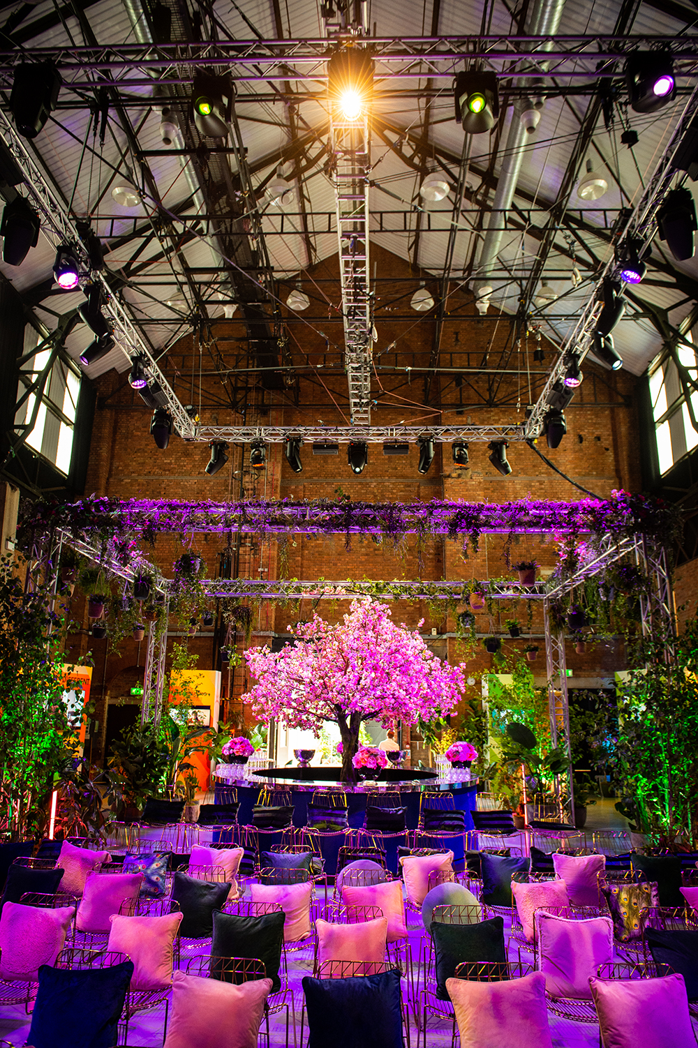 Large industrial space filled with artificial foliage for an event