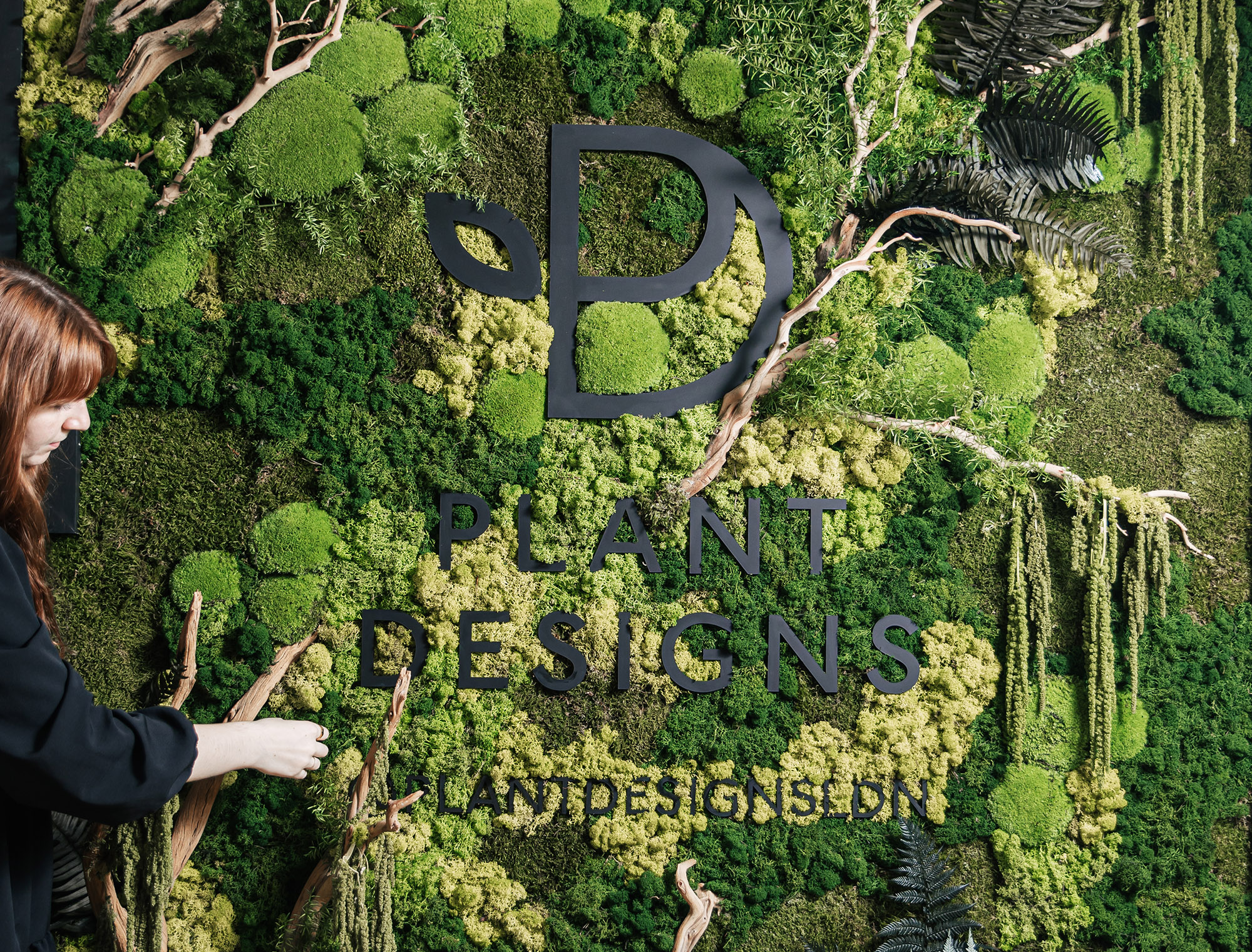 A large moss wall with company logo branding