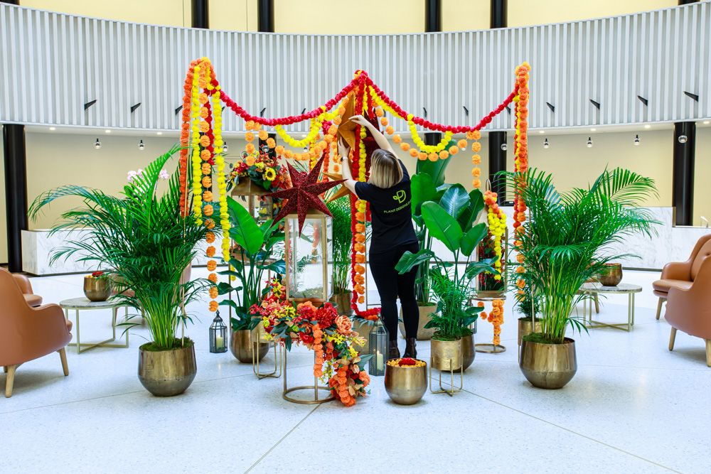 A person putting up colourful Diwali event decorations in an office atrium