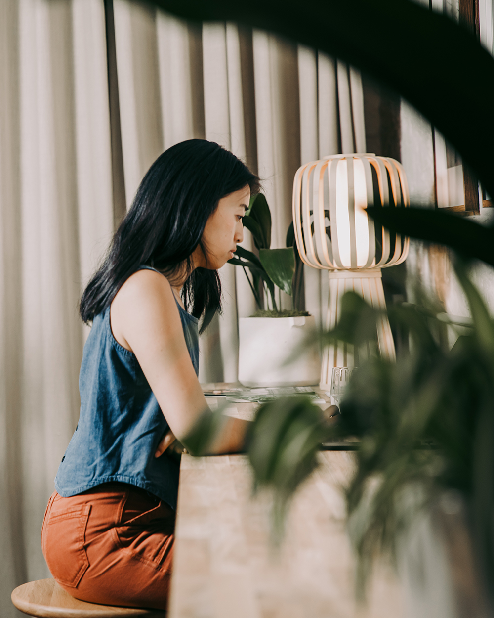 A person sat at a desk surrounded by plants